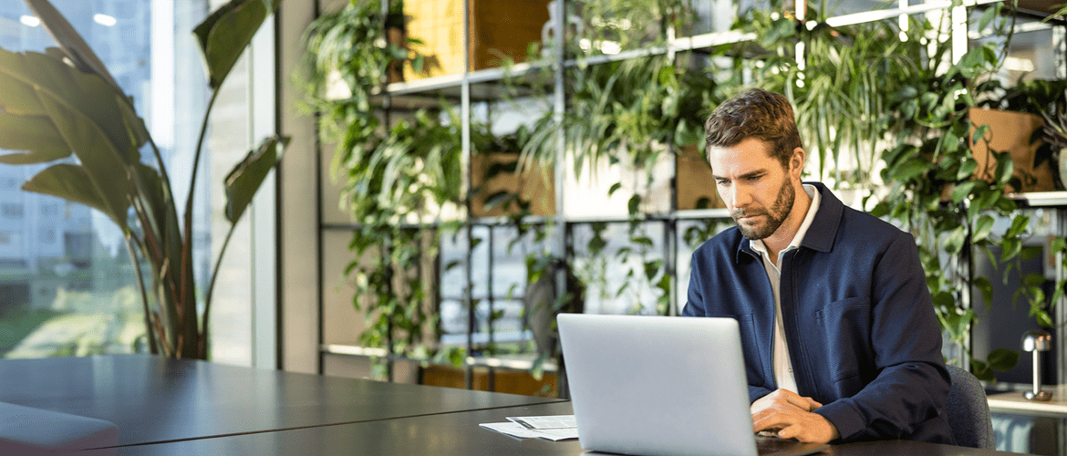 Employee reviewing company policies on a laptop at a modern desk, reflecting a commitment to transparent workplace guidelines and professional conduct.