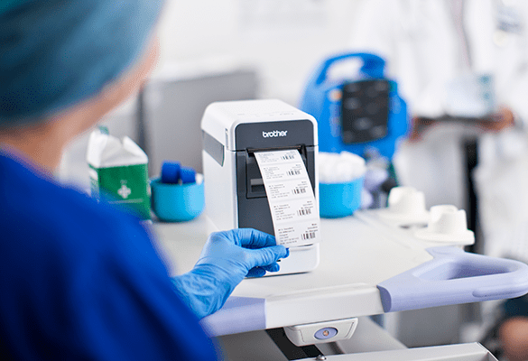 A healthcare worker uses a Brother TD label printer to print out labels